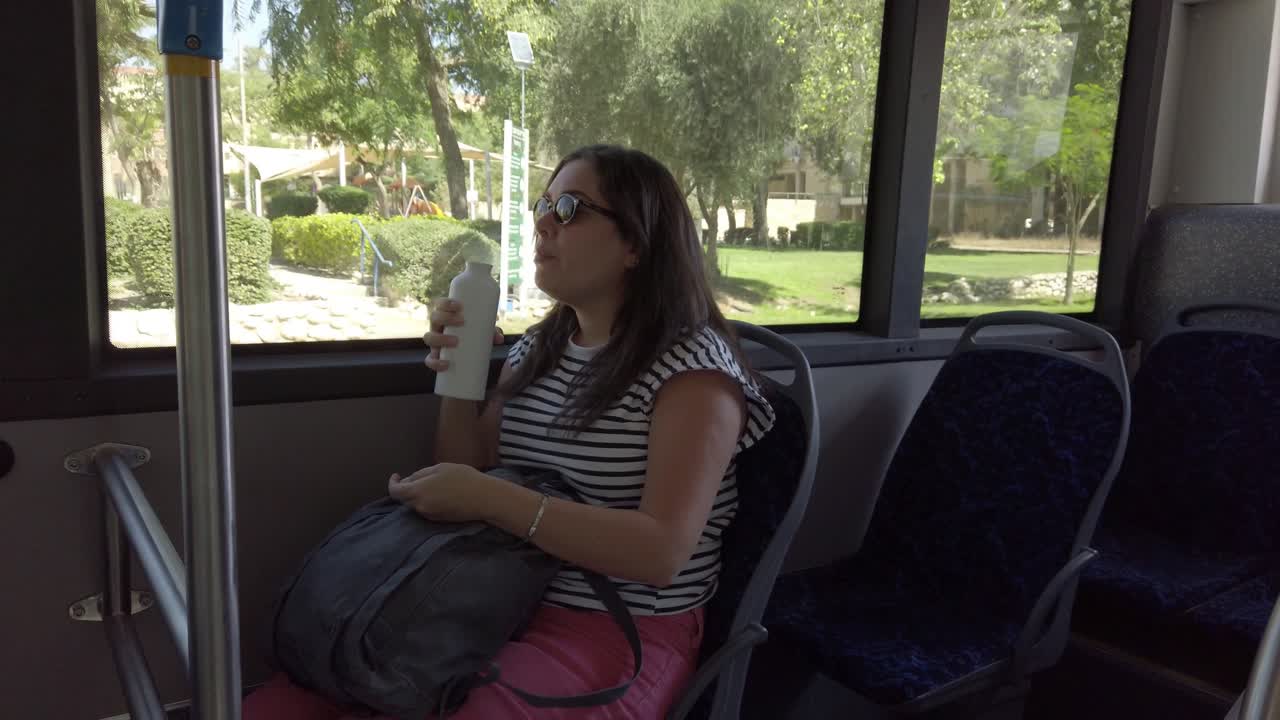 mujer bebiendo en un autobús