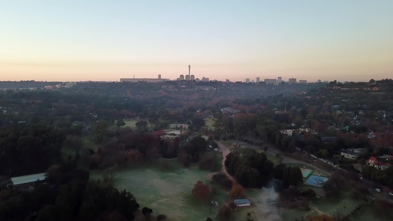 Rising morning shot revealing Johannesburg, South Africa from Zoo Lake