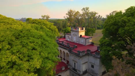 Drone-shot-flying-towards-the-estancia-Santa-Cándida-in-Entre-Ríos,-Argentina-during-golden-hour