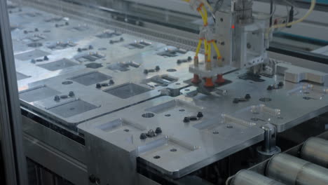 Timelapse of robot arms picking up parts from trays on an automated conveyor line