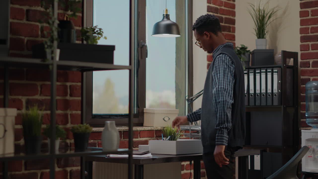 Stressed man getting fired from company job and packing up office things