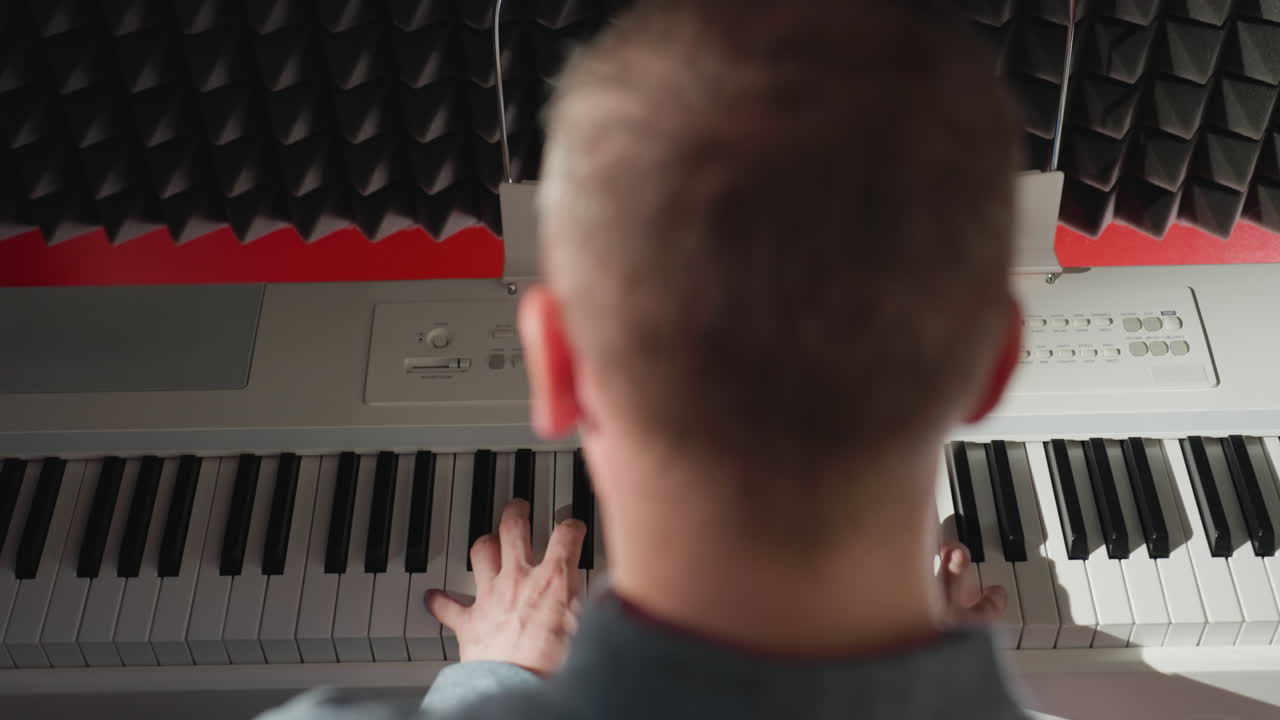 피아노에 앉아있는 한 남자의 뒷면, 그의 손은 우아하게 키를 연주, 은 검은 음향 거품 배경에 설정