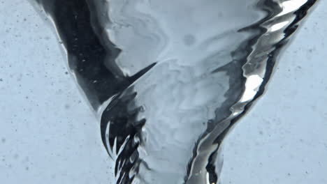 Closeup-blueberries-falling-aqua-swirling-into-funnel.-Water-berries-spinning