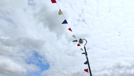 colorful flags waving against cloudy sky