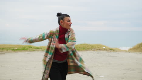 on the beach woman with energetic mood walks dancing to the rhythm of music