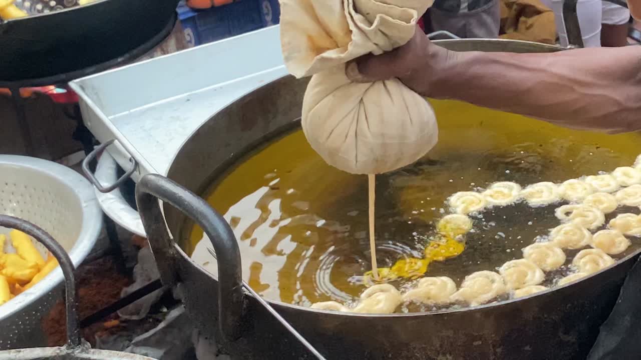 vendedor que cocina el jalebi hecho a mano tradicional en aceite en