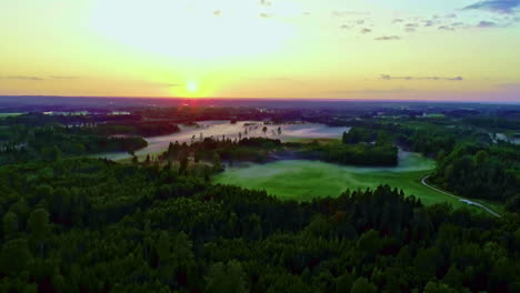 fly over picturesque countryside landscape with greenery forest in misty golden sunrise