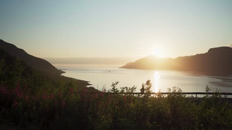 vibrant sunlight over mountains and lake over flakstad village in senja island, northern norway