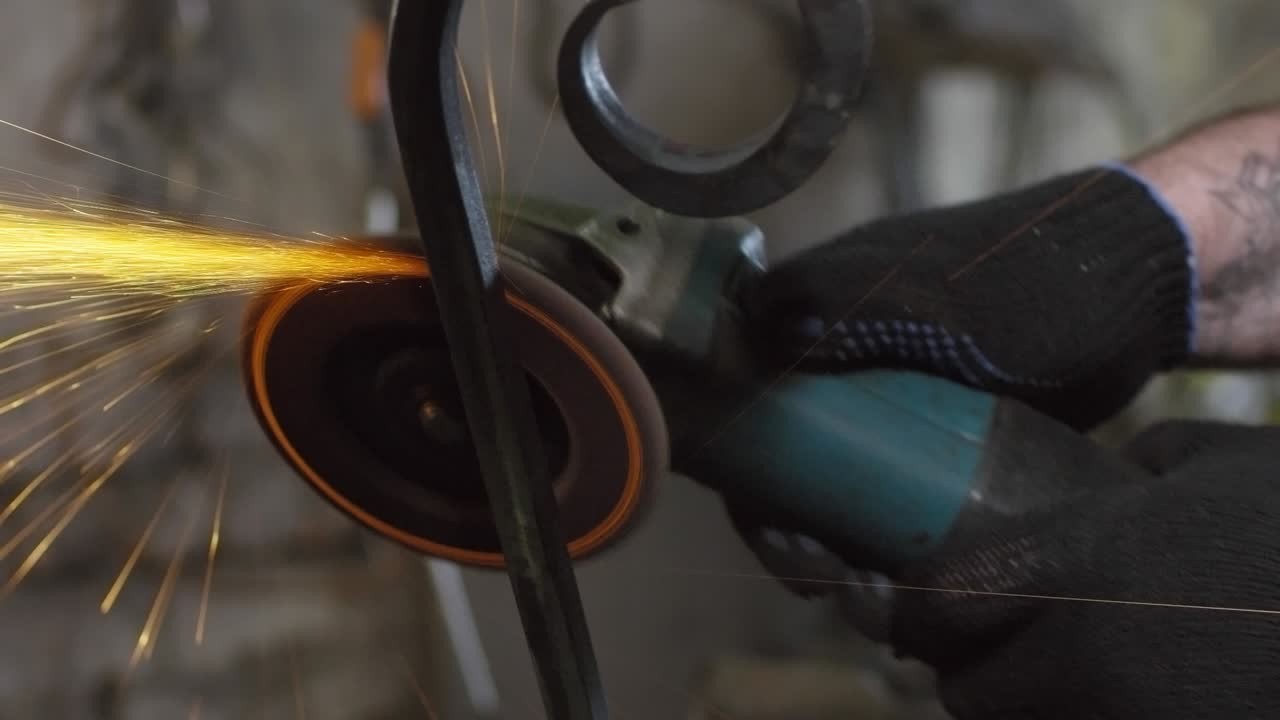 artesano que utiliza una lijadora manual en la herrería