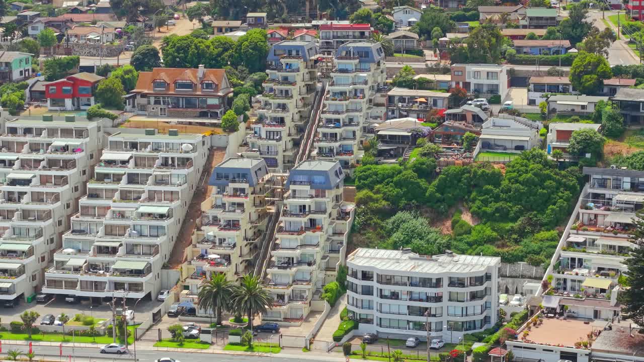 Vista aérea panorâmica de um complexo residencial exclusivo aninhado no topo de uma colina, com terraços em degraus em Concón, Chile, em um dia ensolarado, arquitetura adaptativa.
