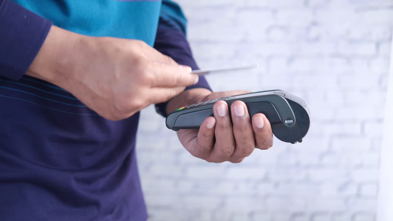 지불을 하기 위해 판매점 터미널을 사용하는 사람