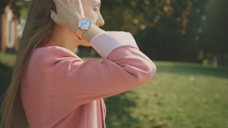 Seitenansicht-Einer-Schönen-Kaukasischen-Frau-In-Rosa-Longline-Blazer,-Die-Am-Frühen-Morgen-Durch-Den-Park-Spaziert---Kamerafahrt