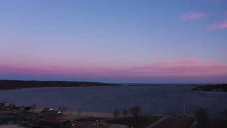 an aerial shot over an empty park looking at the bay during a beautiful sunrise