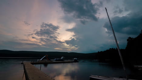 Sunset-time-lapse-looking-over-lake-with-dock-boats-and-beautiful-colorful-clouds