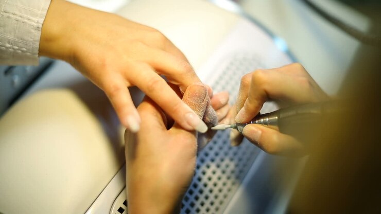 Woman making manicure. Professional manicure for woman by manicure machine