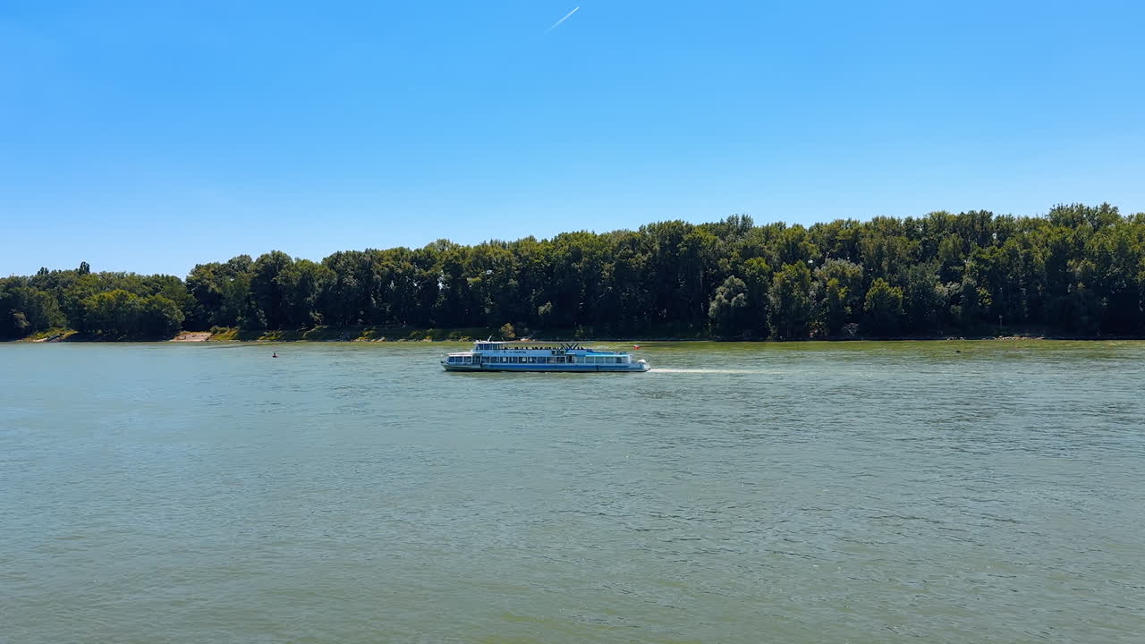 Riverboat floats by the river on sunny day. Travelling by the Danube River in Bratislava, Slovakia