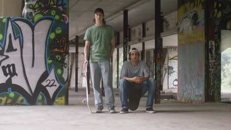 Caucasian-skateboarders-in-a-ruined-building.