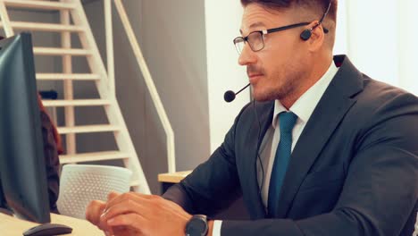 Business-people-wearing-headset-working-in-office