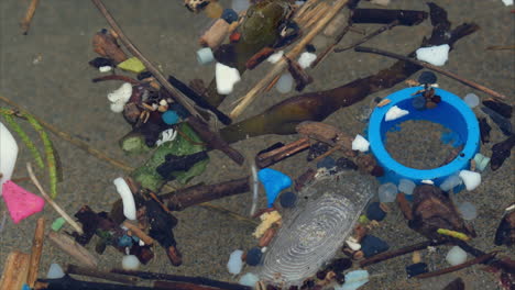 trash floating on beach waters, macro close up