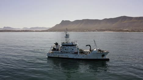 marine research motor vessel drifting off the coast operating its crane and equipment