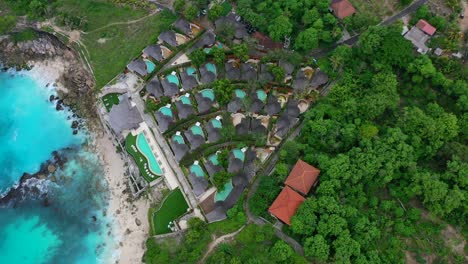 aerial circling overhead pool villas on cliff at