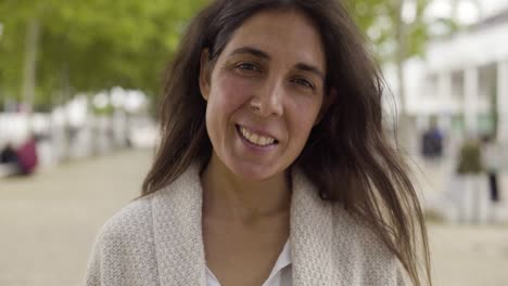 una morena feliz de mediana edad mirando a la cámara.