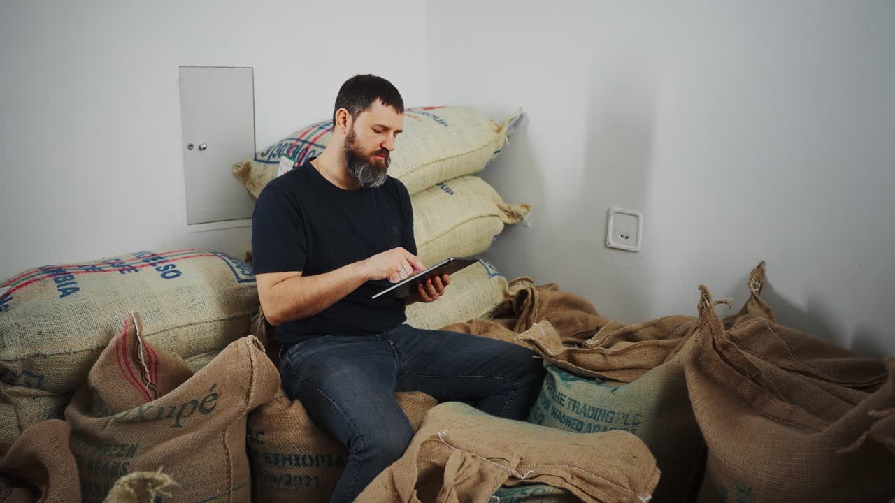Man working on tablet in a coffee warehouse