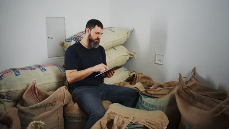 man working on tablet in a coffee warehouse