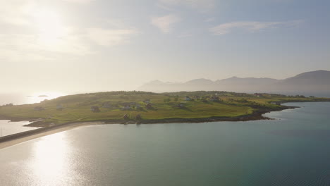 panorama aéreo de camiones sobre holdoya, noruega, mientras la luz del sol brilla sobre el agua del océano.
