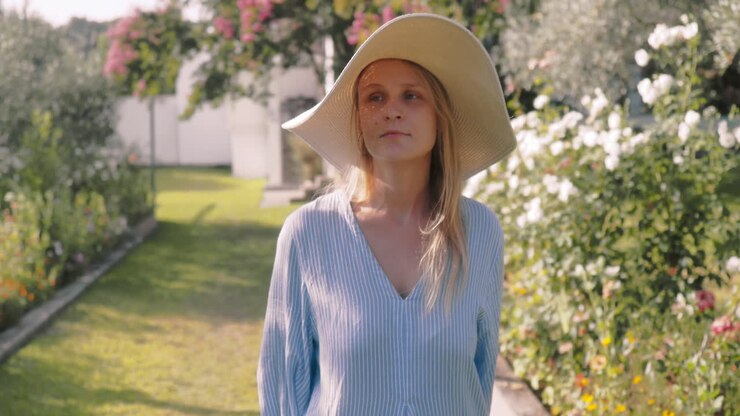 Woman examining plant in garden with care