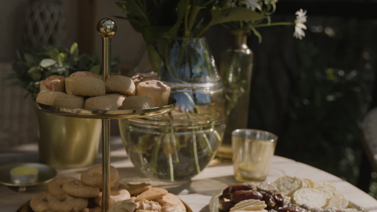 Afternoon tea spread with pastries, cookies, and snacks in a garden setting