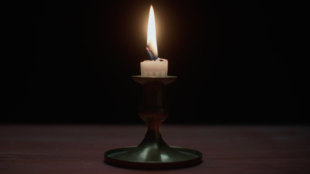 A candle burs out in the dark room