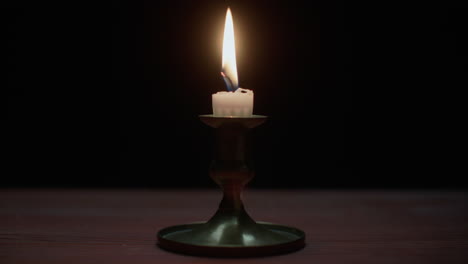 a candle burs out in the dark room