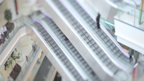 people in motion in escalators at the modern shopping mall. tilt shift lens shooting with super shallow depth of field.