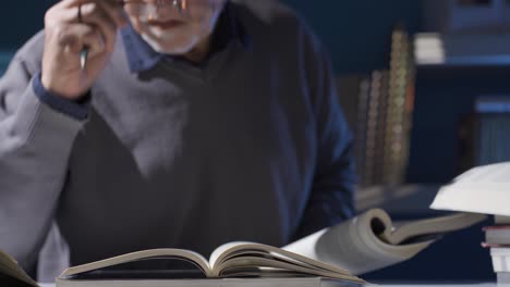 researcher man working with historical archives and scientific books in his study.