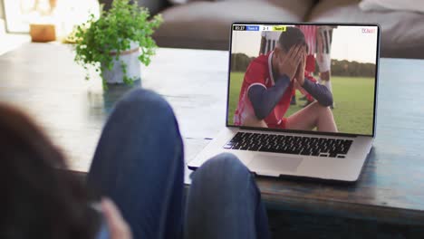 Video-Einer-Frau,-Die-Auf-Dem-Sofa-Sitzt-Und-Zu-Hause-Auf-Dem-Laptop-Fußball-Schaut