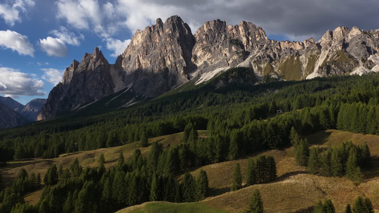The dolomites, Cortina d'Ampezzo, mountains, alpine trees, grass land fields. Sunset revealing aerial