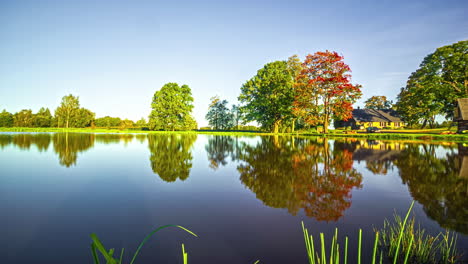 Lago-Rural-Con-árboles-Verdes-Y-Cabaña-Bajo-El-Sol-De-Verano,-Timelapse