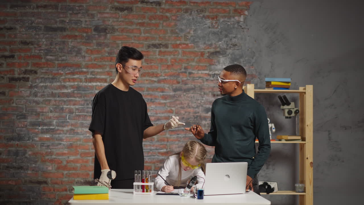 아시아 남성 흑인 동료와 소녀가 실험실에서 온라인 수업을 듣고 있습니다.