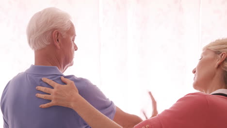 doctor helping a senior man with hand exercise