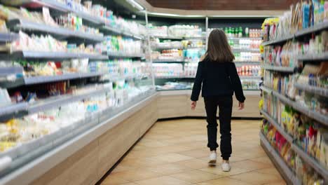 Independent-teenager-in-the-supermarket,-rear-view