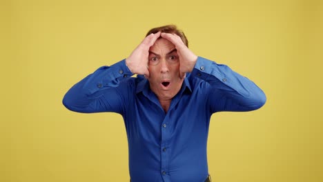 man with hands on head looking surprised