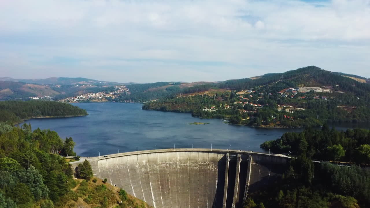 Cars driving through dam located in Montalegre, Portugal - Drone aerial shot backwards movement reveal
