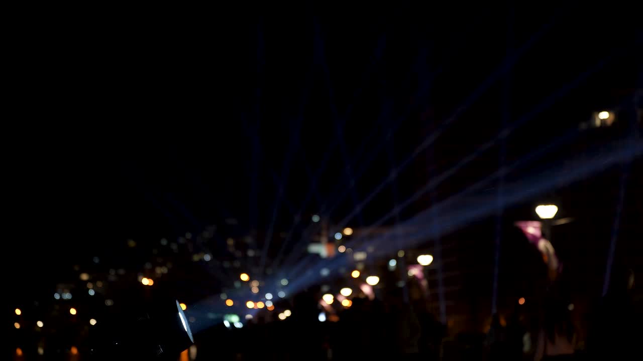 inspiradora sinfonía nocturna de luz y espectáculo de láser, el paseo marítimo lleno de gente, fondo de edificios de la ciudad