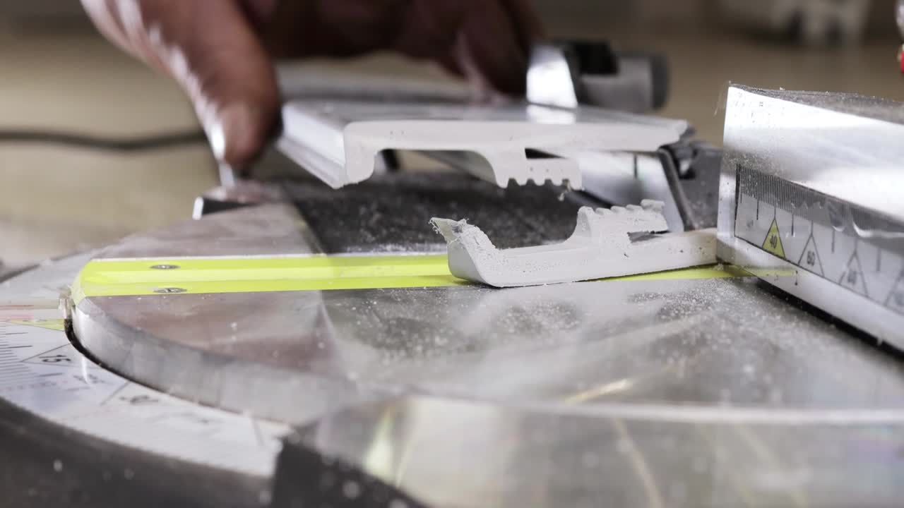 Worker cutting baseboard on the circular saw before installing