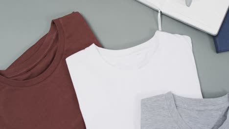 Video-of-flat-lay-of-t-shirts-with-copy-space-on-grey-background