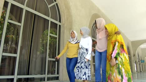 group of students with hijab celebrating, taking selfie and group hug