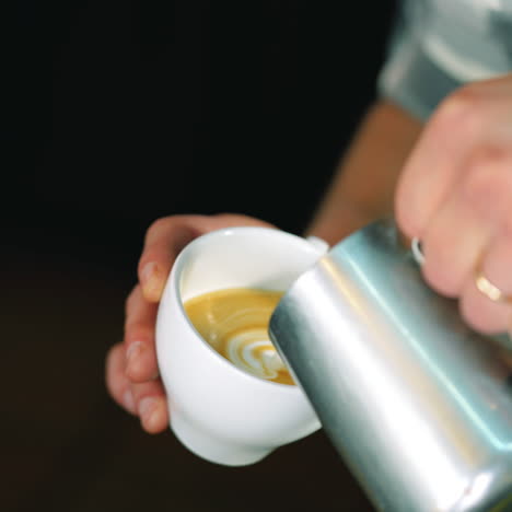 barista pouring milk in coffee cup for making latte art.slow motion shot. art of making cappuccino in a cup sqare video
