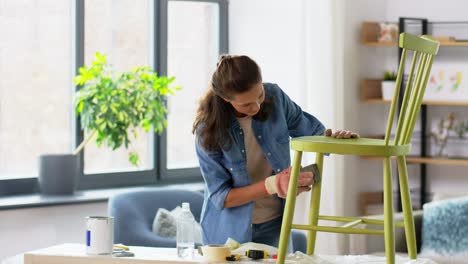 furniture-renovation,-diy-and-home-improvement-concept--happy-smiling-mother-and-daughter-sanding-old-round-wooden-chair-with-sponge-at-home