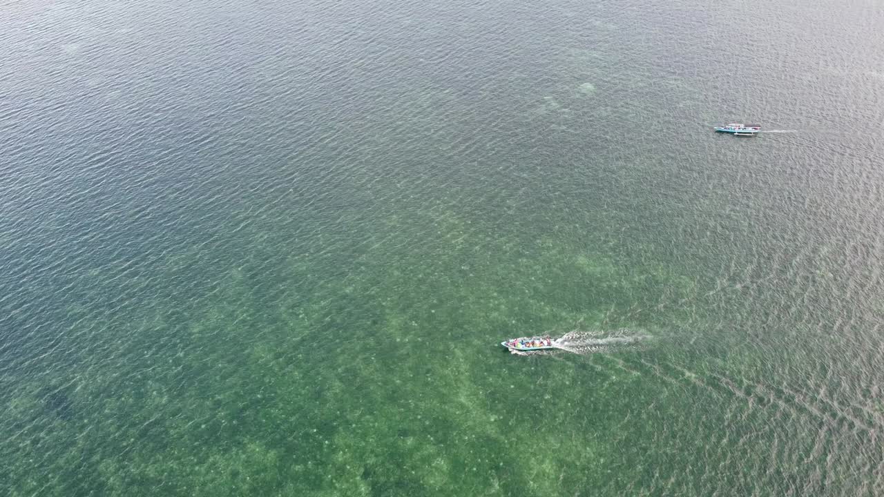 동티모르 아타우로 섬의 목가적인 외딴 열대 섬 주위로 사람들을 옮기는 산호초 위를 이동하는 작은 지역 수상 택시 수송선